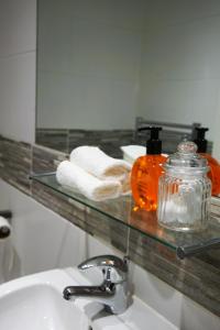 baño con lavabo y estante de cristal con toallas en Loft Living Oxford, en Oxford