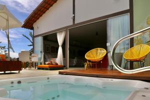 a swimming pool with two chairs and a house at Loft Rua Direita in Pirenópolis