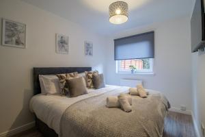 una camera da letto con un letto grande con cuscini sopra di The Larky - Modern 2 Bed Cottage in Larkhall a Larkhall