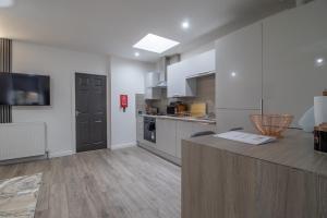 una cucina con mobili bianchi e un piano di lavoro di The Larky - Modern 2 Bed Cottage in Larkhall a Larkhall