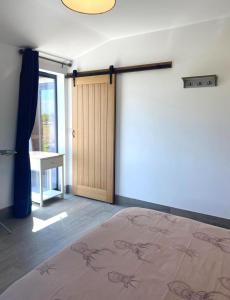 a bedroom with a bed and a wooden door at HORSESHOE LUXURY ACCESSIBLE LODGE Sleeps 4 at Fairview Farm in Ravenshead Nottingham near Sherwood Forest ,Dog Friendly Farm Stay in Blidworth