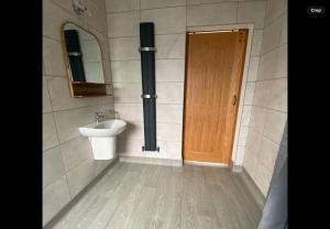 a bathroom with a sink and a toilet and a door at HORSESHOE LUXURY ACCESSIBLE LODGE Sleeps 4 at Fairview Farm in Ravenshead Nottingham near Sherwood Forest ,Dog Friendly Farm Stay in Blidworth +24 photos