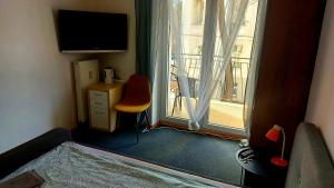 a room with a television and a chair and a window at CitySOPOT-Centrum-Dąbrowskiego in Sopot