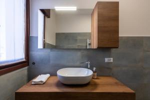 a bathroom with a white bowl sink on a wooden counter at Venice - Mestre Dream Apartment in Venice +23 photos