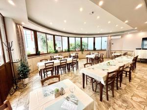 a restaurant with tables and chairs and windows at A Bárány in Kaposvár