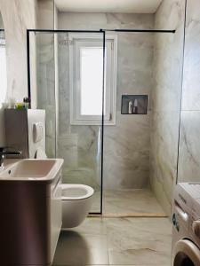 uma casa de banho com um chuveiro, um WC e um lavatório. em SleepIn Shkoder em Shkodër