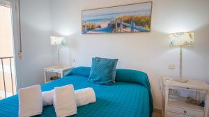 a bedroom with a blue bed with towels on it at Villas del Golf 27 in Manilva +29 photos