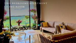 a living room with two couches and a table at Kensington Sunrise at Sg Palas,PalasHorizon in Tanah Rata