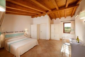 a bedroom with a bed and a table and a window at Gallura style Res Baia Del Mirti B4 1BedAp sleeps4 in Vignola Mare +87 photos