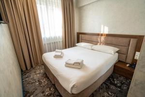 a bedroom with a bed with two towels on it at MILDOM Express in Almaty