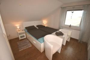 una camera da letto con un letto, un tavolo e una finestra di Ferienwohnung Spitz a Dornum