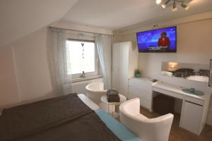 una camera da letto con un letto e una TV a parete di Ferienwohnung Spitz a Dornum Altre 13 foto