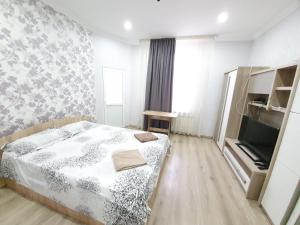 a small bedroom with a bed and a tv at Apartment in The Heart of the Capital in Chişinău