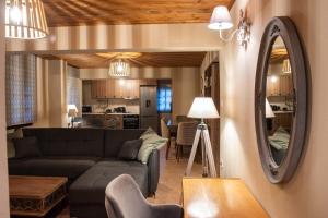 a living room with a couch and a mirror at Dandy Villas Tsagkarada-Sweet Green Apple-Mini Pool in Tsagarada