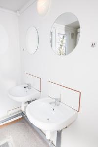 a white bathroom with two sinks and a mirror at Hostel Metro in Warsaw +28 photos