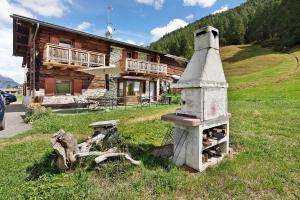 Una chimenea de piedra frente a una cabaña de troncos en Appartamento Legnameir Bait da Rez, en Livigno