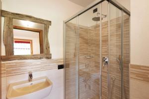 un baño con lavabo y ducha en Appartamento Legnameir Bait da Rez, en Livigno