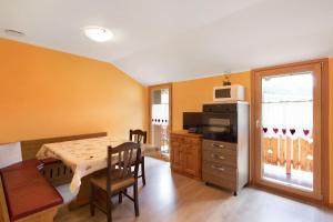 Una cocina con una mesa y un comedor. en Appartamento Legnameir Bait da Rez, en Livigno 17 fotos más
