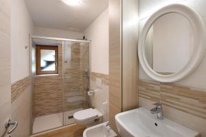 a bathroom with a sink and a toilet and a mirror at Appartamento Pizalegn Bait da Rez in Livigno