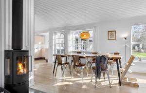 a dining room with a fireplace and a table and chairs at Beach Front Home In Bogense With Wifi in Bogense