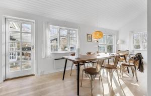 a dining room with a table and chairs and windows at Beach Front Home In Bogense With Wifi in Bogense