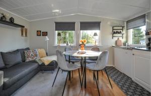 a living room with a couch and a table and chairs at Amazing Home In Grums With Wifi in Grums