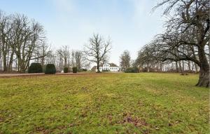 a large field with a white house in the background at Nice Home In Ekeby With Wifi in Ekeby