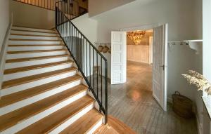 a staircase in a home with wooden floors and a chandelier at Nice Home In Ekeby With Wifi in Ekeby