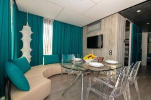 a dining room with a glass table and blue chairs at Arena Grand Kazela Camping Homes in Medulin