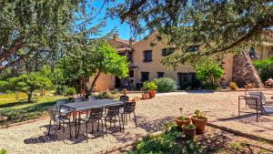 a patio with a table and chairs in front of a house at Masia Mimosa Montaña in Darnius