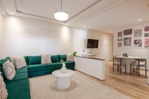 a living room with a green couch and a table at Modern 1 Bedroom W Terrace- Rabat City Center in Rabat