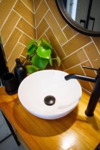 a white sink on a wooden table with a plant at Golden Suite Plaza in Corralejo