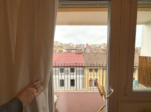 a person looking out of a window at a building at Trieste Mia Rooms in Trieste