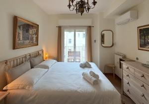 a bedroom with a large white bed with towels on it at Trieste Mia Rooms in Trieste
