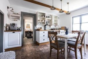 a kitchen and dining room with a table and chairs at VándorLÓ Vendégház in Komló