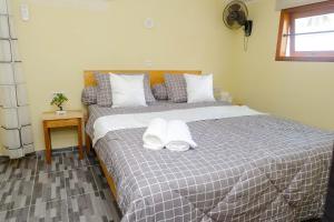 a bedroom with a bed with two towels on it at Amaro Homestay in Nuhu Tawun