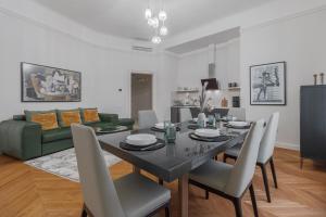a dining room with a table and a green couch at SUPREME Experience at Markovits Palace in Oradea