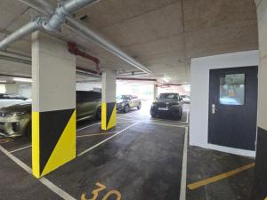 a parking garage with cars parked in it at Snuggle Inn Serviced Apartments, Great choice for large groups, Contractors, Business Executives and Family Vacations in the stunning valley of Surrey Hills, secure Private Parking, Offering Easy Train Access to London, Gatwick airport, M25 in Warlingham
