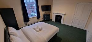 a bedroom with a bed with a flower on it at SELF CHECK-IN QUICK ROOMz WAKEFIELD in Wakefield