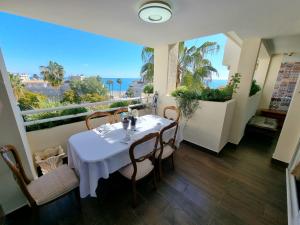 ein Esszimmer mit Tisch und Blick auf das Meer in der Unterkunft Luxury 2 bedrooms Apartment in La Carihuela Torremolinos 20 meters in from of beach in Torremolinos