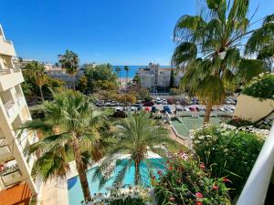 Blick auf ein Resort mit Palmen und einem Pool in der Unterkunft Luxury 2 bedrooms Apartment in La Carihuela Torremolinos 20 meters in from of beach in Torremolinos