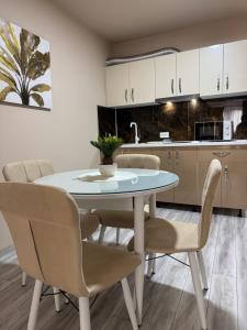 a kitchen with a dining room table and chairs at Relax House Apartments in Craiova +24 photos