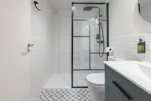 a white bathroom with a shower and a toilet at The Little Village Apartments in Valencia +131 photos