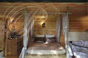 a bedroom with a bed in a wooden room at Les Cabanes de Brassac in Brassac