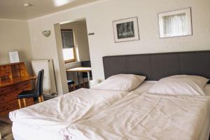 a bedroom with two white beds and a desk at Pension Apart in Glashütten