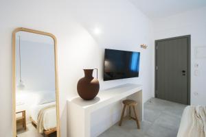 a bedroom with a mirror and a vase on a dresser at Paris Studios & Apartment in Agia Paraskevi