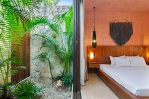 a bedroom with a bed and a wall with plants at Private & Modern 2-BR Villa of La Veleta in Tulum +37 photos