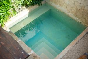 a pool of water with a bench in front of it at Private & Modern 2-BR Villa of La Veleta in Tulum