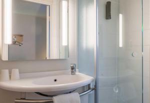 a white bathroom with a sink and a shower at B&B HOTEL Troyes Centre in Troyes