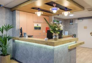 an office with a reception counter with flowers on it at B&B HOTEL Troyes Centre in Troyes +18 photos